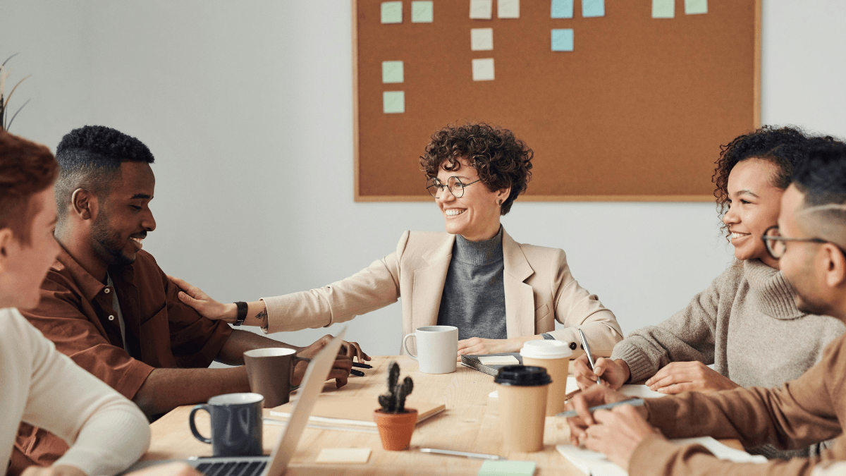 Grupo de profesionales reunidos en una mesa de trabajo, algunos vasos de café en la mesa.